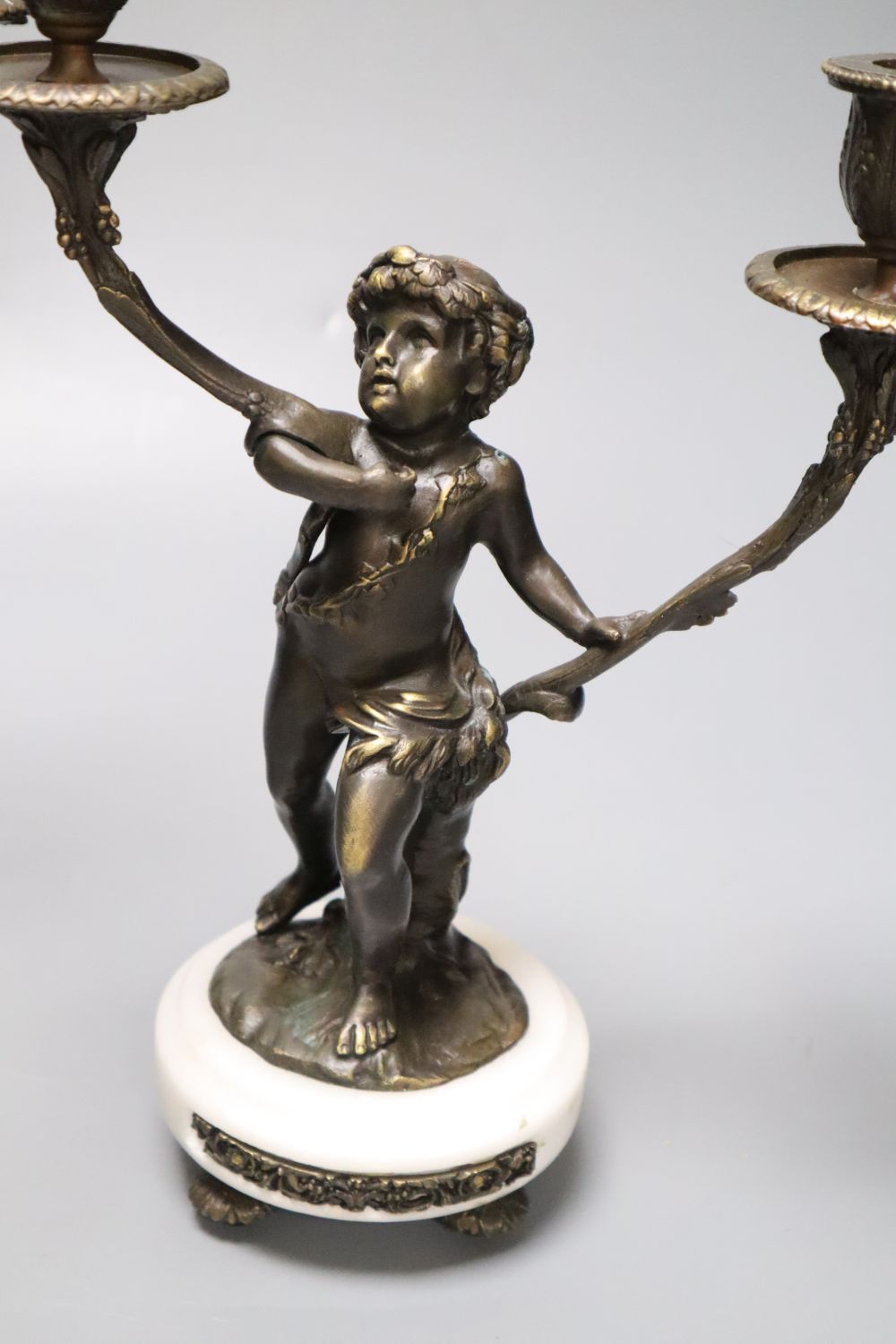 A pair of bronzed-finished metal figural candelabra, on circular bases, height 31cm